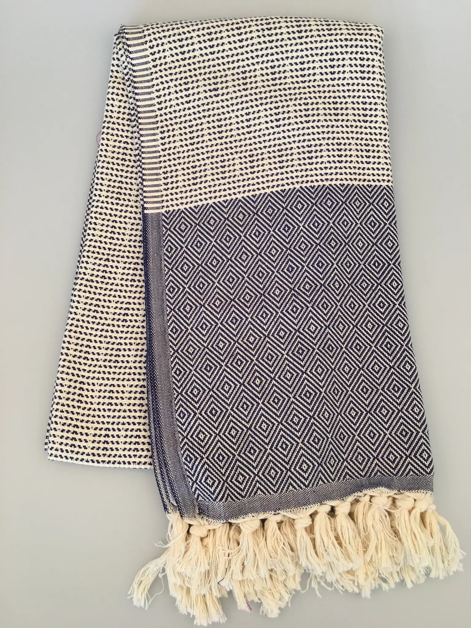 "Lycia Patara Turkish towel peshtemal in navy and cream with diamond pattern, fringed edges, folded view"