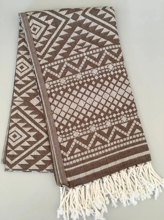 "Jacquard peshtemal in brown and cream with geometric patterns, featuring white fringes at one end."