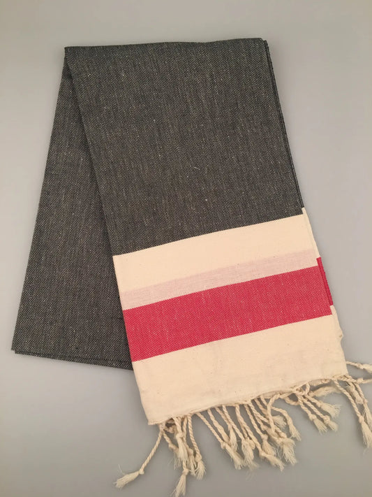 "Gray Turkish towel peshtemal with red and cream striped border, fringed edges, laid flat on a light background."