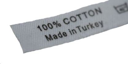 White cotton label with black text reading "100% COTTON" and "Made in Turkey," showing a care symbol on the left.