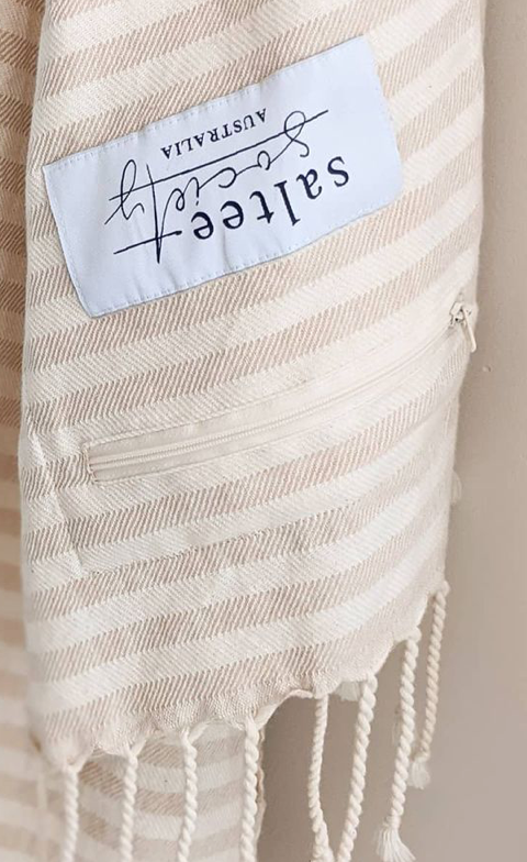 "Beige striped cotton label with 'Saltree Australia' text, attached to a light fabric with fringed edges."